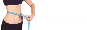 یک زن در حال اندازه گرفتن دور شکم، نقش کمربند و پماد لاغری در تناسب اندام
