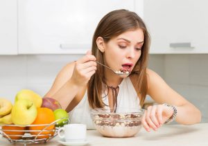 یک زن در حال غذا خوردن به ساعتش نگاه می کند